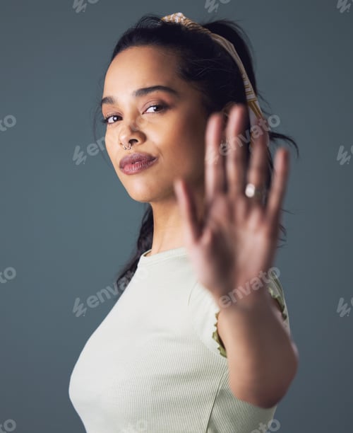 Preview: Shot of a woman holding up her hand while standing against a grey background