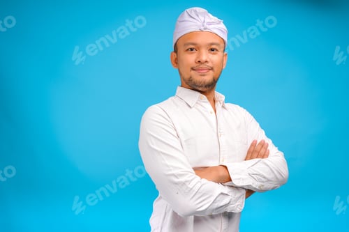 Preview: Confident Balinese man wearing Indonesian traditional udeng posing with a crossed arms.