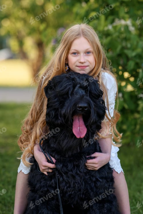 Preview: beautiful girl sitting in the spring park with bouquets of flowers and a black Russian terrier dog