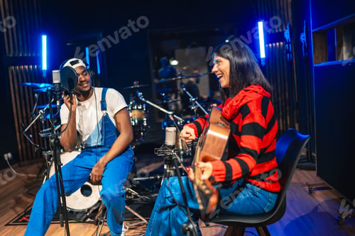 Preview: Two musicians recording song in professional studio with acoustic guitar and microphone