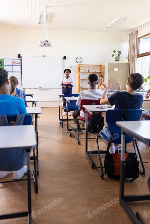 Visualização: Professora indiana conduzindo discussões em sala de aula com estudantes sentados em mesas na escola