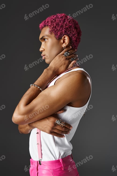 Preview: serious good looking man with crossed arms and hand behind neck on gray backdrop, fashion and style