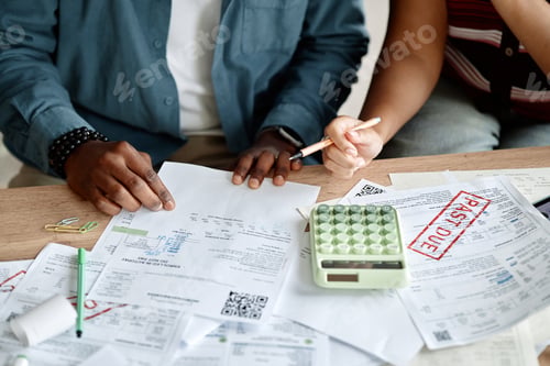 Preview: Young Multiethnic Team Analyzing Invoices and Bills Together at Desk