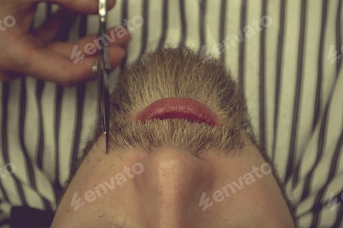 Preview: Getting perfect shape. Close-up side view with scissors and comb. Master Barber does hairstyle