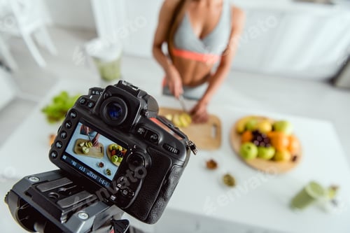 Preview: selective focus of digital camera with girl cutting apple on screen