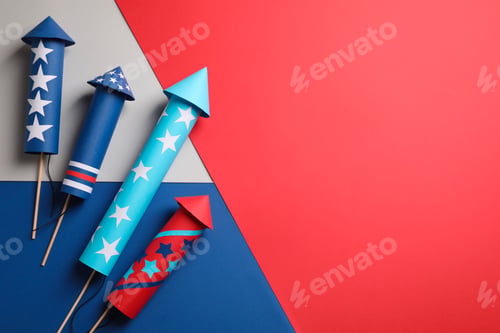 Preview: Firework rockets on color background, flat lay with space for text. Festive decor