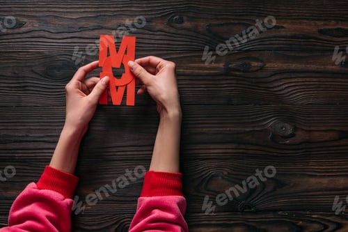 Preview: cropped shot of woman holding mom lettering in hands