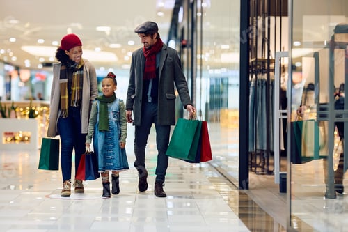 Preview: Happy family enjoying in Christmas shopping at the mall.