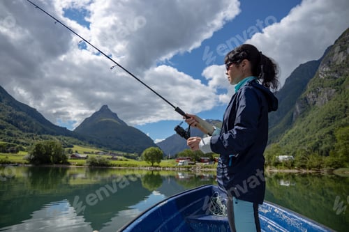 Preview: Woman fishing on Fishing rod spinning in Norway.