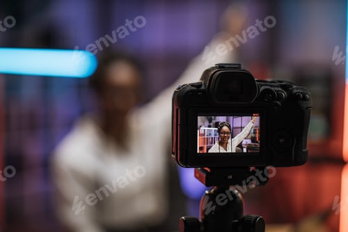 Visualização: Vista da tela da câmera de vídeo com atraente mulher de negócios afro-americana confiante