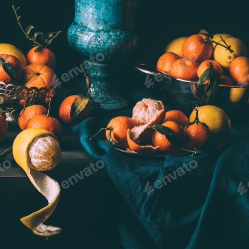 Preview: close up view of arrangement of fresh lemons and tangerines in bowl and strainer on table with dark