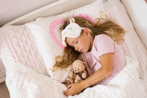 Preview: Little girl sleeping with a soft toy in her bed on a pillow is a sweet calm sleep of a child.