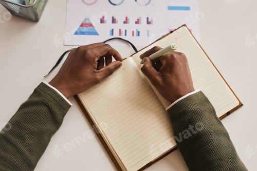 Preview: African-American Man Writing in Planner Top View