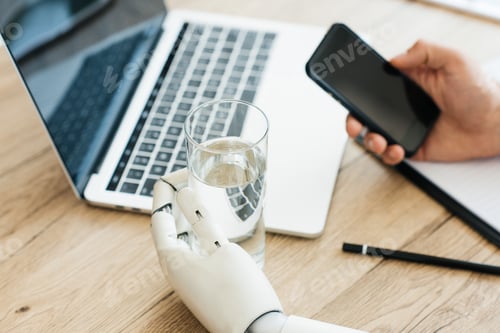 Preview: close-up view of person using smartphone and hand of robot holding glass of water