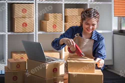 Preview: Female SME small business entrepreneur packs product, inspects parcel for delivery to customers