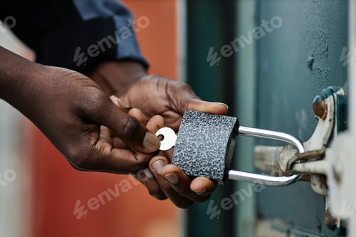 Preview: Black man opening lock on container door
