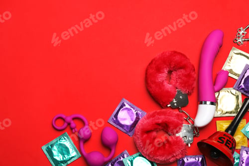Preview: Different sex toys on red background, flat lay. Space for text