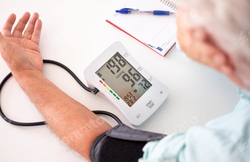 Preview: Old senior man using medical device to measure blood pressure - people suffering from hypertension