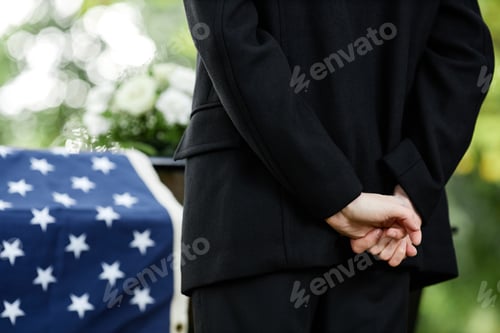 Preview: Woman clasping hands behind back at funeral ceremony