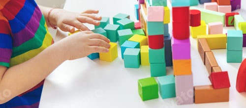 Preview: A child builds from blocks. Selective focus.