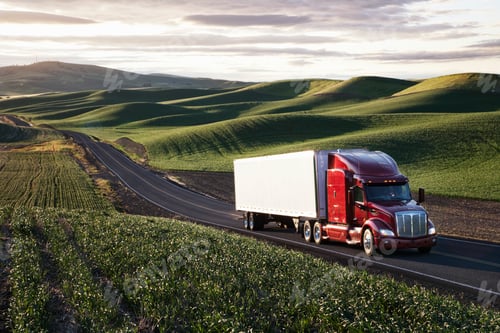 Preview: Peterbilt Class8 commercial truck driving through farmlands in eastern Washington, USA at sunset.