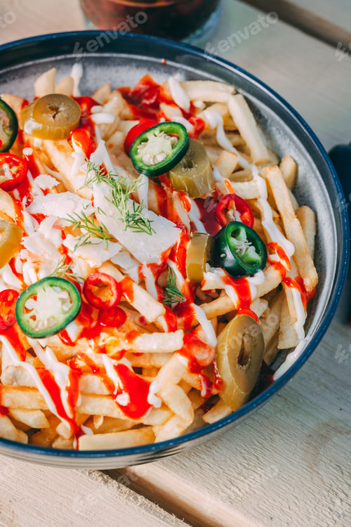 Preview: Bowl of french fries topped with sauce