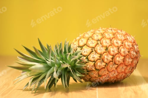 Preview: Ripe pineapple on a yellow wooden background
