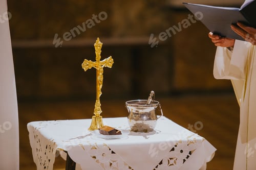 Preview: Closeup of the cross on the table with a priest next to it during a wedding celebration