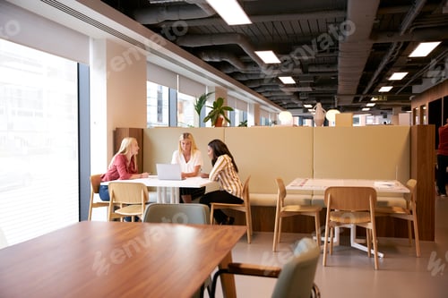 Preview: Group Of Young Businesswomen Sitting Around Table And Collaborating On Task