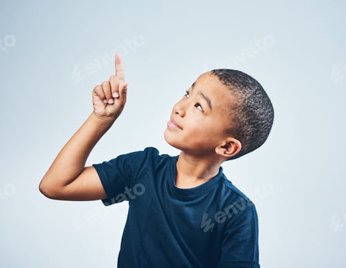 Preview: Studio shot of a cute little boy pointing against a grey background
