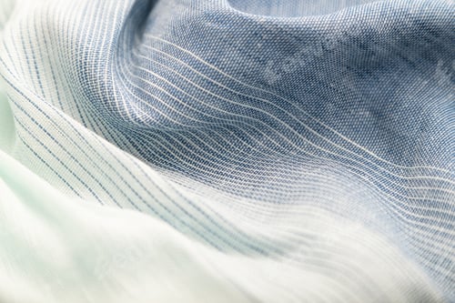 Preview: Fragment of blue and white linen tissue. Side view, textile background and texture.