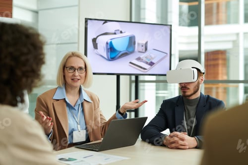 Preview: Confident mature business coach explaining something to employees