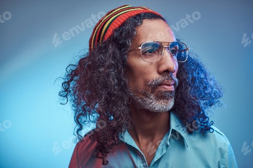 Preview: Studio portrait of African Rastafarian male wearing a blue shirt and beanie.