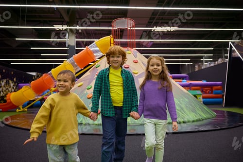 Preview: Happy preschool children having fun in play area standing in circle