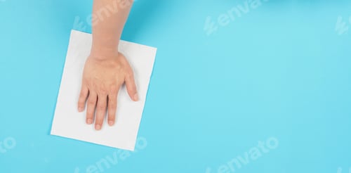 Preview: Hand is wiping and hold white paper tissue on blue background.