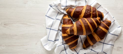 Preview: Homemade Croissants with Chocolate on a white wooden background, overhead view.