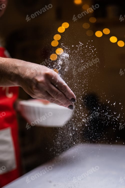 Preview: someone sprinkling flour on food in the air from above