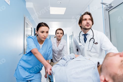 Preview: Worried doctors transporting unconscious patient on gurney