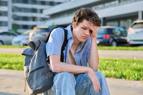 Preview: Upset sad unhappy young male sitting outdoor on steps