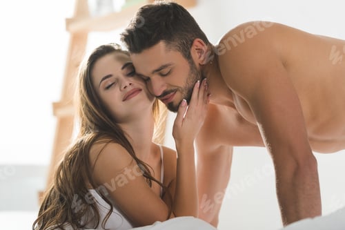 Preview: happy young couple in underwear cuddling in bed in morning
