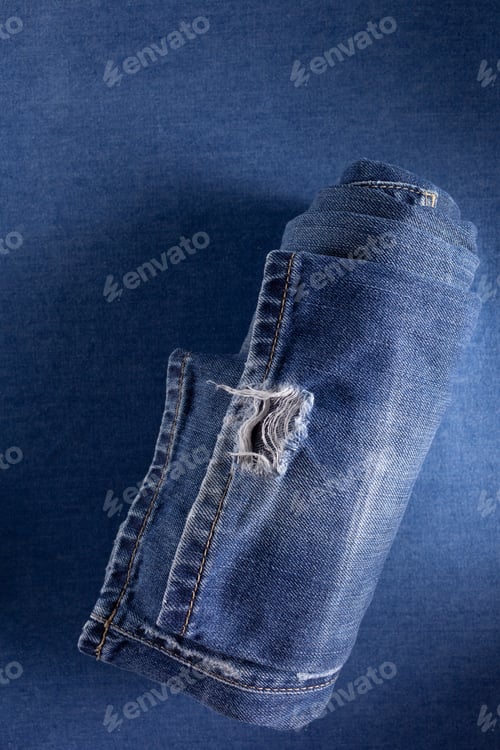 Preview: Folded blue jeans denim background texture. Jeans fabric material surface
