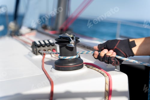 Preview: Sailor adjusting sailboat rope on a winch during regatta