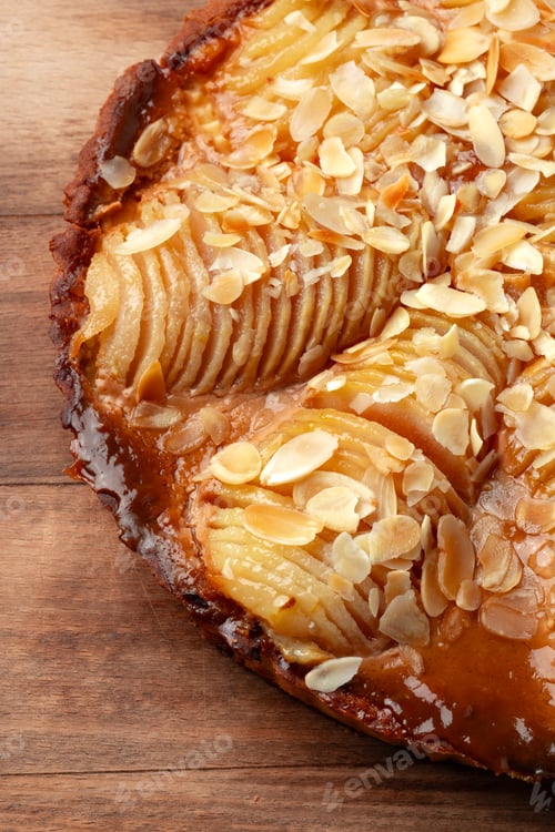 Preview: Fresh pear tart with almond slices on a wooden table