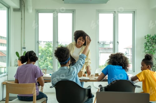 Visualização: Crianças felizes em idade escolar tendo aulas na aula de STEM do ensino fundamental sentadas em mesas.