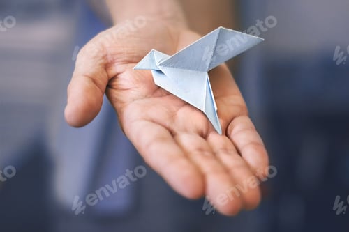Preview: male right palm with a paper blue dove on blue background