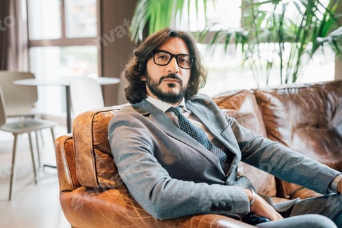 Preview: Confident professional relaxing in a stylish office lounge.
