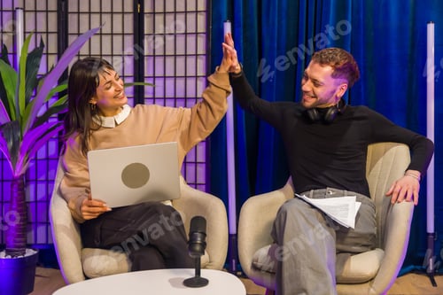 Preview: Content creators high fiving celebrating success in podcast studio