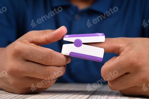 Preview: Close up of young man's hand using pulse oximeter