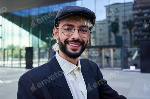 Preview: Hipster businessman looking at camera smiling, standing outside workplace.
