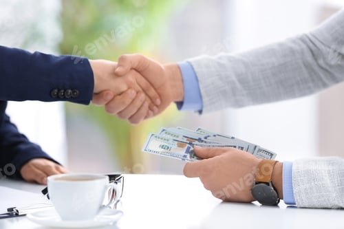 Preview: Man shaking hands with woman and offering bribe at table in office